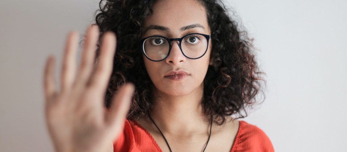 Woman holding up her hand saying no.